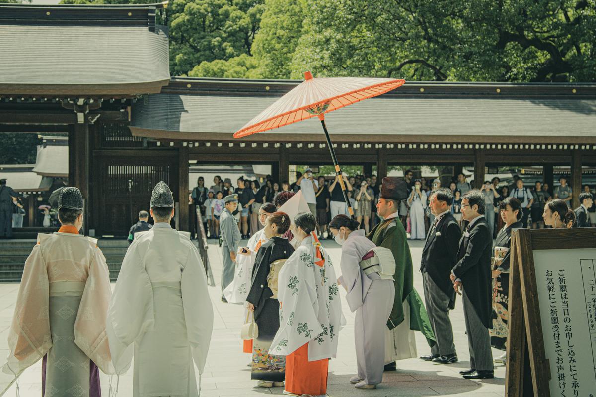 Shinto wedding procession at Meiji Shrine under a red parasol
