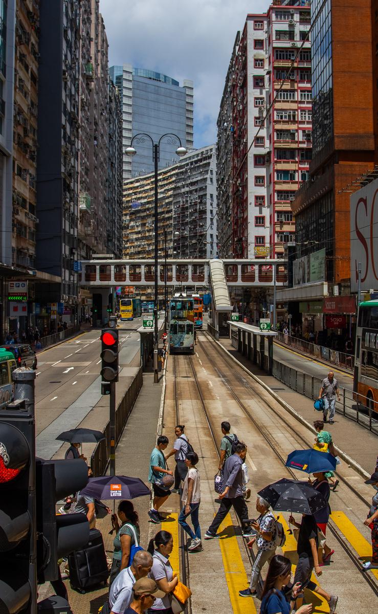 Hong Kong tram crossing with dense high-rises